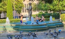 Sıcaklardan bunalan çocuklar süs havuzuna girerek serinledi